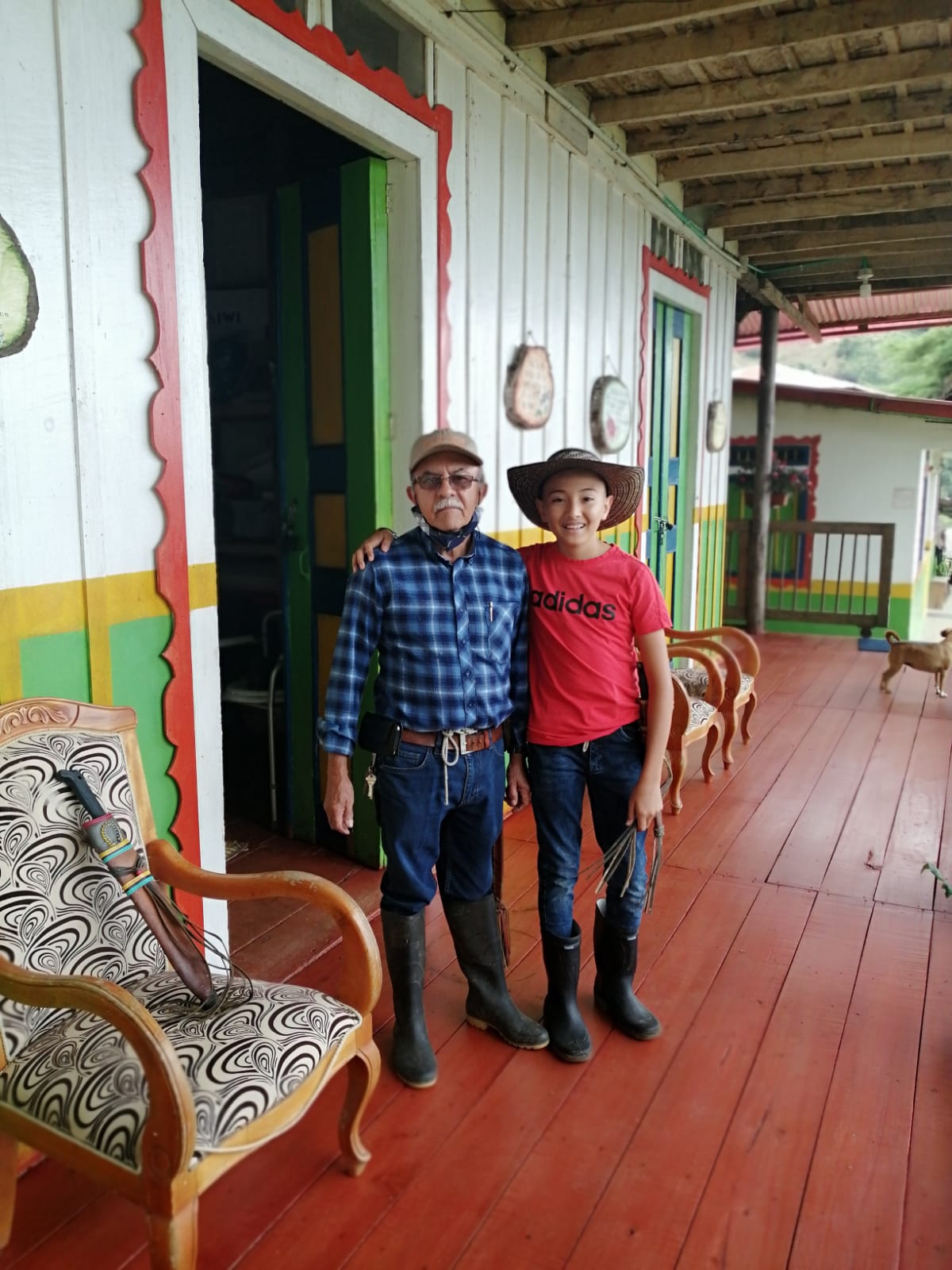 Don Norber junto a su nieto en el corredor de la casa de la finca