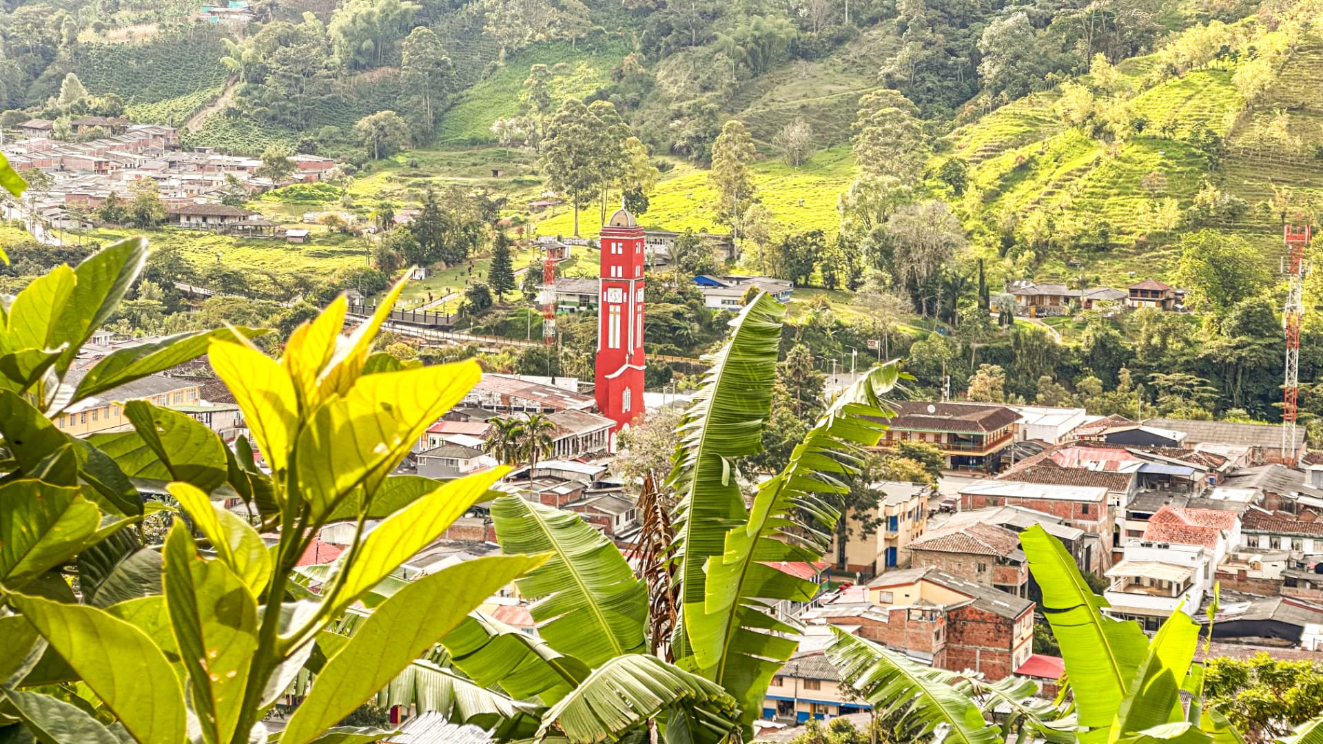 Pueblo cafetero del Quindío con su torre roja rodeado de montañas verdes